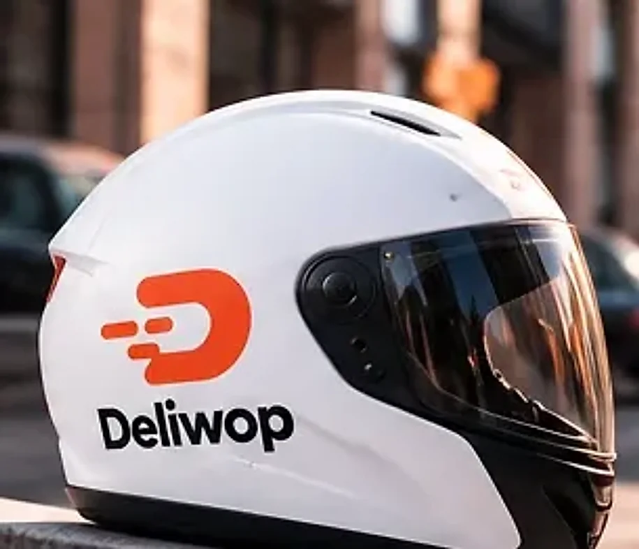 Casque Deliwop blanc posé sur un rebord de pierre, dans une rue